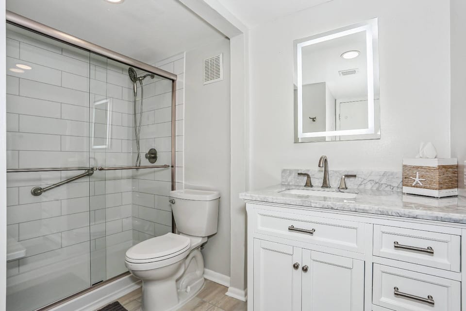 Completely updated primary bathroom with new vanity and tiled, walk-in shower