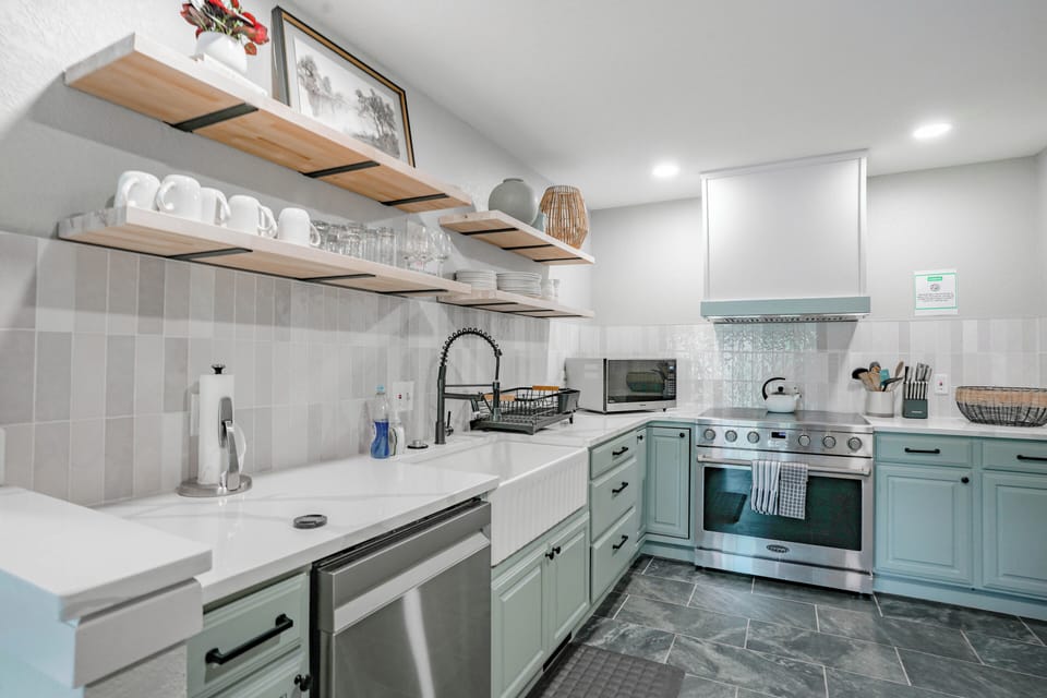Bright, modern kitchen with open shelving and stainless steel appliances