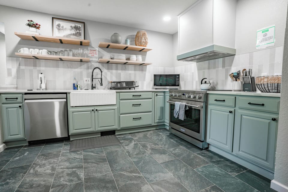 Stylish kitchen featuring open shelves and a spacious farmhouse sink