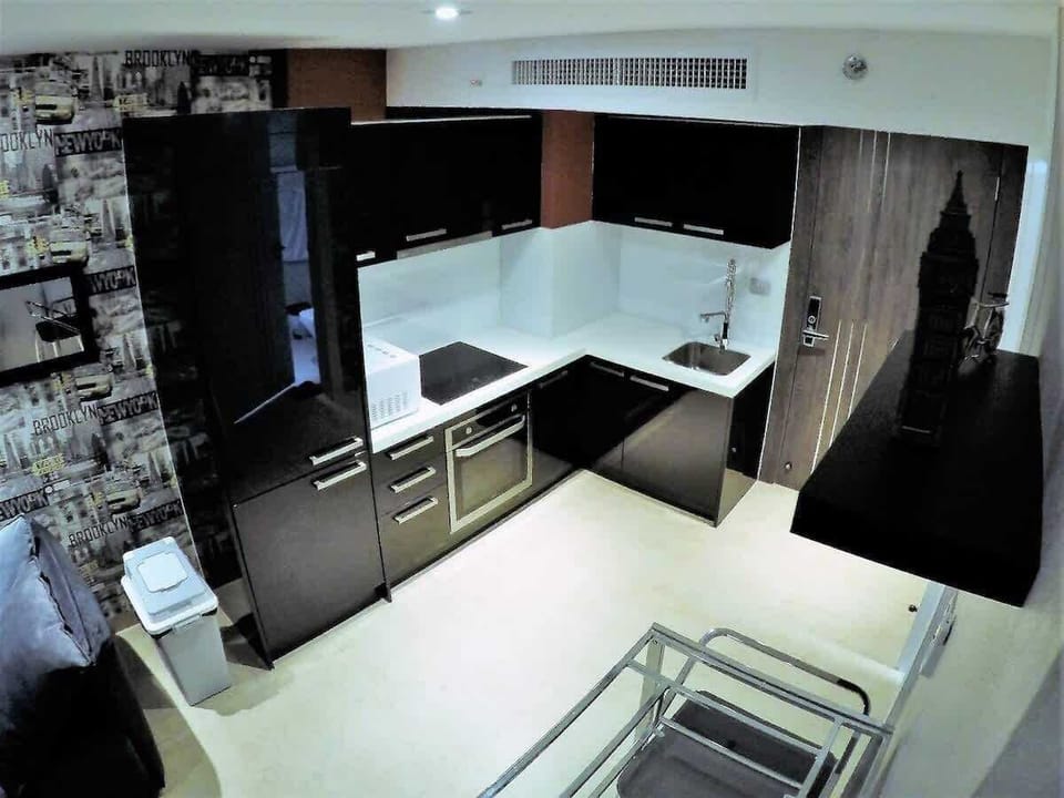 Cuisine spacieuse et haut de gamme, équipée d'un frigo encastré, grand four, micro-onde, et hotte aspirante, conçue pour les amateurs de gastronomie.