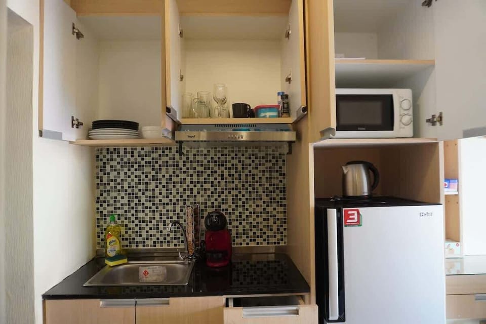 Cette cuisine est équipée pour rendre votre séjour agréable : micro-ondes, bouilloire, machine à café, et un évier design pour un maximum de praticité. 