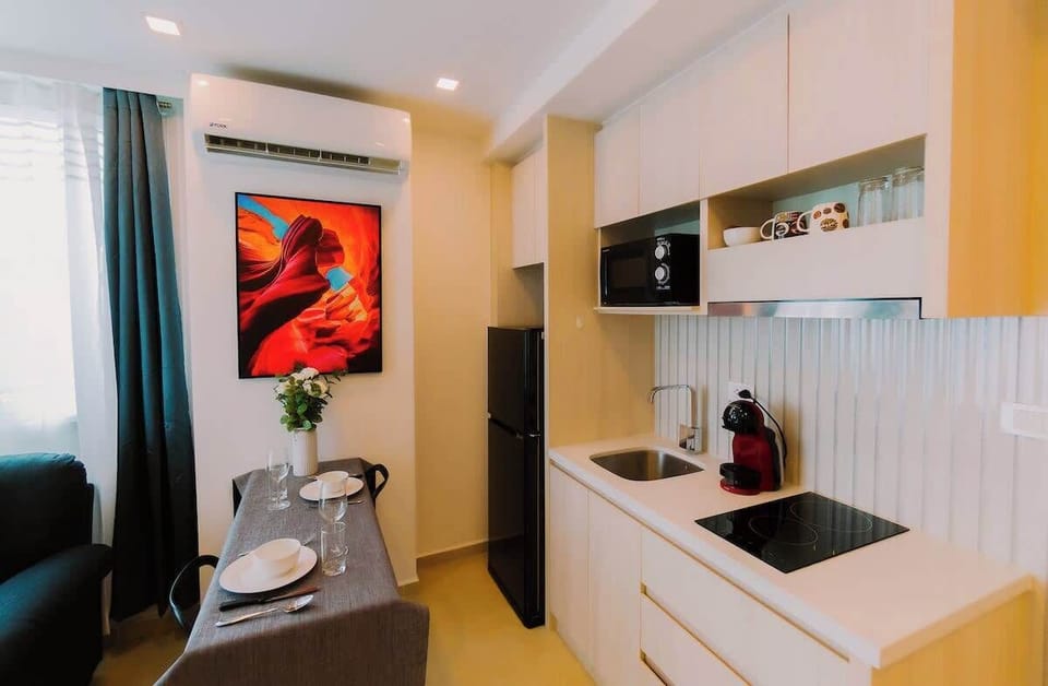 Salle à manger simple et intime, idéale pour partager des repas en toute convivialité. Décoration raffinée avec une touche artistique en arrière-plan, offrant une ambiance chaleureuse et accueillante. Parfait pour des moments de détente et de plaisir