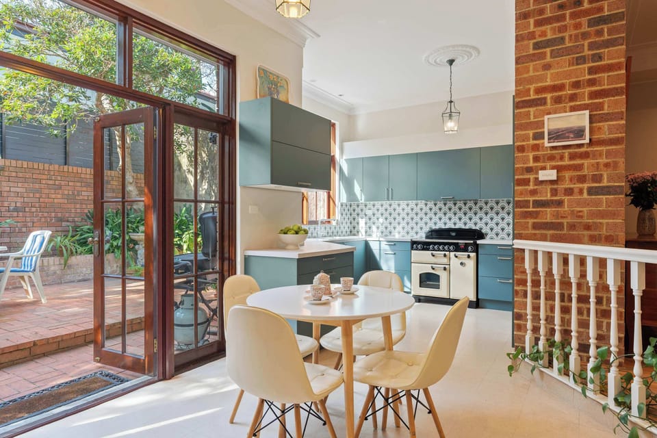 A bright corner of the kitchen with a round table and four chairs, perfect for casual dining.