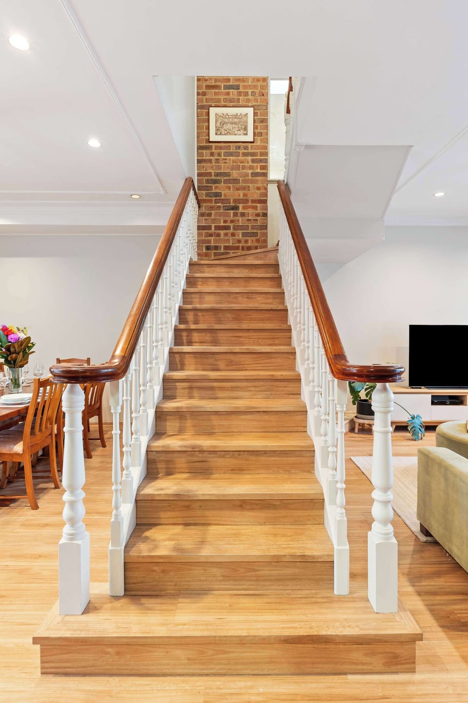A view of the staircase leading up, featuring a flight of around 16–20 steps with a sturdy handrail and a bright, welcoming feel.