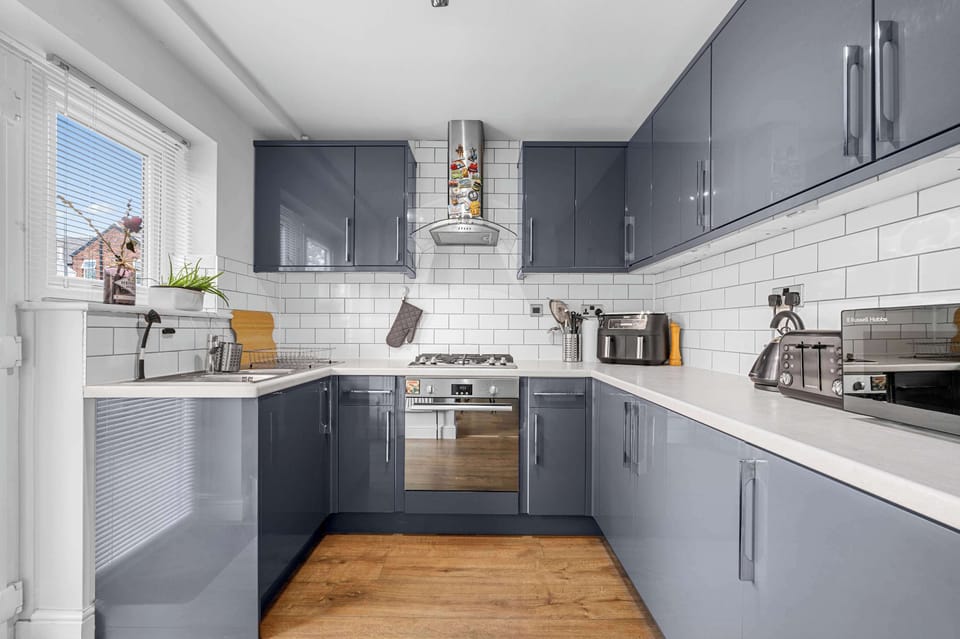 Sleek modern kitchen with plenty of worktop space, well stocked with cookware and utensils for preparing meals at home