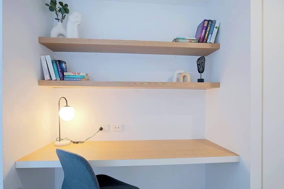 The dedicated study nook features a built-in desk, warm lighting, open shelving and an ergonomic chair—perfect for focused workdays or mapping out your next Brisbane adventure.