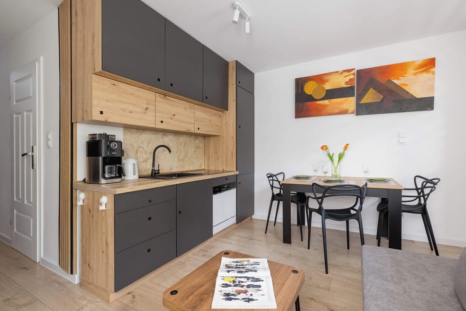The sleek, fully equipped kitchenette features an electric cooktop, microwave, refrigerator, and ample cabinet space.