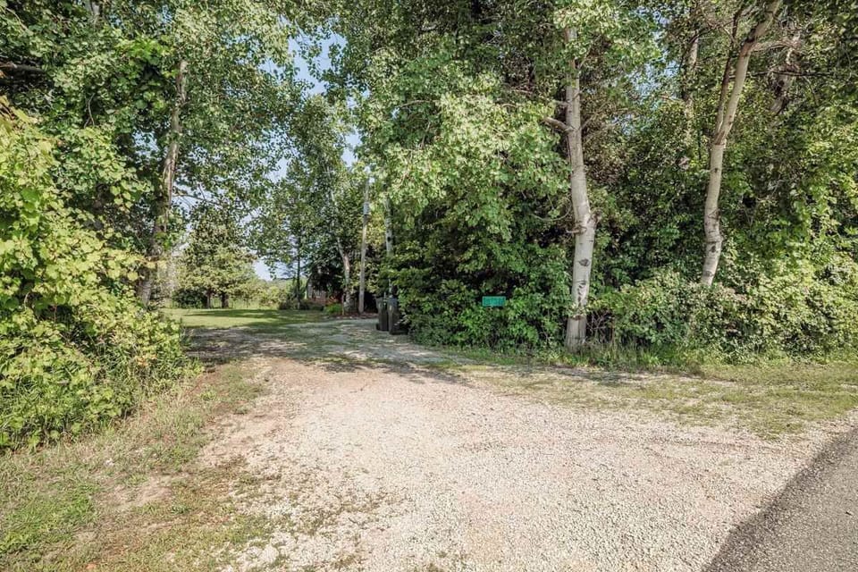 A peaceful view of the entrance driveway leading through the woods to the cozy waterfront cottage—welcoming you to a private and tranquil Door County retreat.