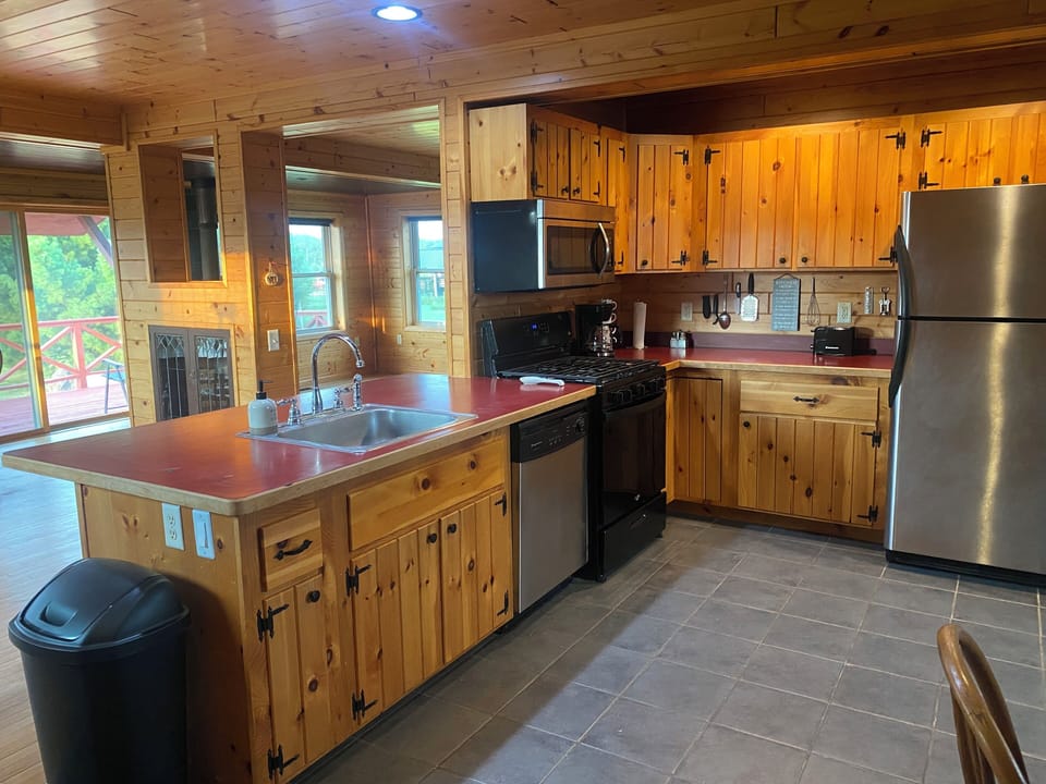 Large kitchen area with dishes,, silverware, pots & pans.