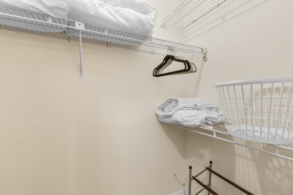 Keep your beachwear organized in this roomy walk-in closet with extra linens, hangers, and storage space—perfect for extended seaside stays.