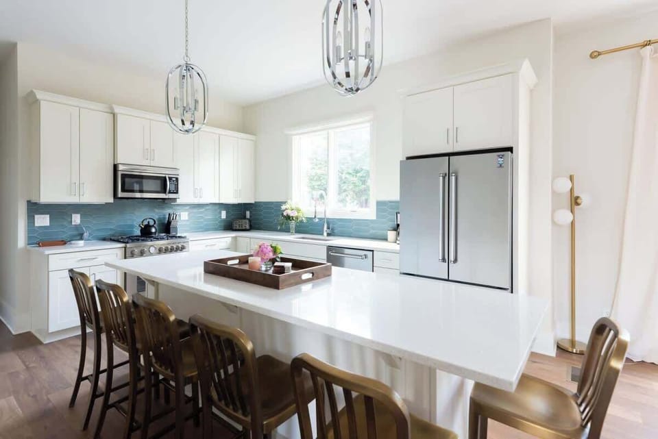 Gather around the warm and welcoming kitchen island for a cozy cocktail hour, ideal for relaxing and sharing good conversation together.
