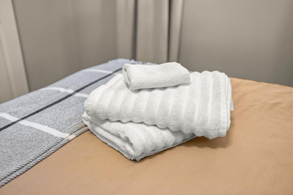 Fresh white towels folded with care—simple comforts ready to welcome you