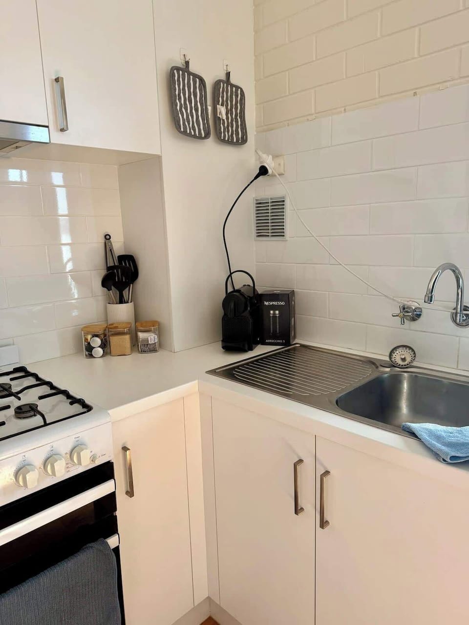 We've thought of everything for your culinary comfort. This kitchen corner features a Nespresso machine for your daily caffeine fix, alongside readily available cooking utensils, spices, and a functional sink, ensuring a pleasant stay.