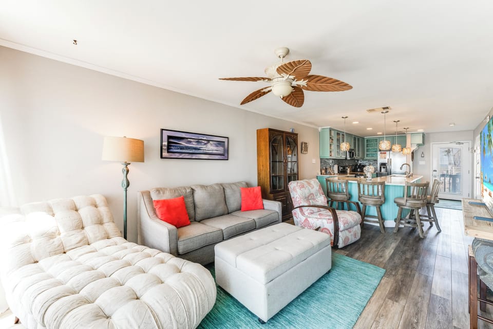 Unwind in your spacious open-concept retreat with tropical ceiling fans, plush seating, and turquoise accents that bring coastal charm indoors.