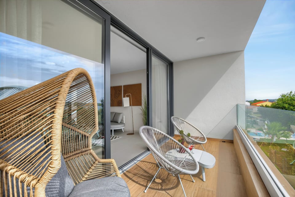 Balcony corner with rattan chairs, sea breeze, and afternoon sun. 