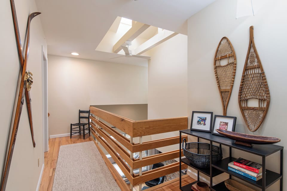 - Upstairs loft hallway with skylight windows   - Rustic snowshoe décor enhances cabin style   - Comfortable landing connects guest bedrooms