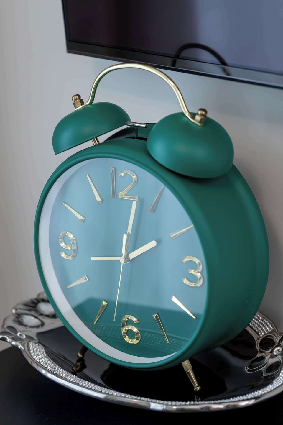 The retro-style green alarm clock on the bedside table adds a charming touch and character to the space.