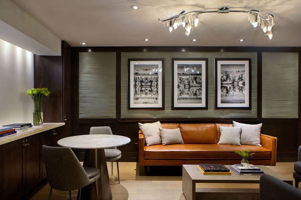 Unwind on the leather sofa beneath warm, modern lighting.