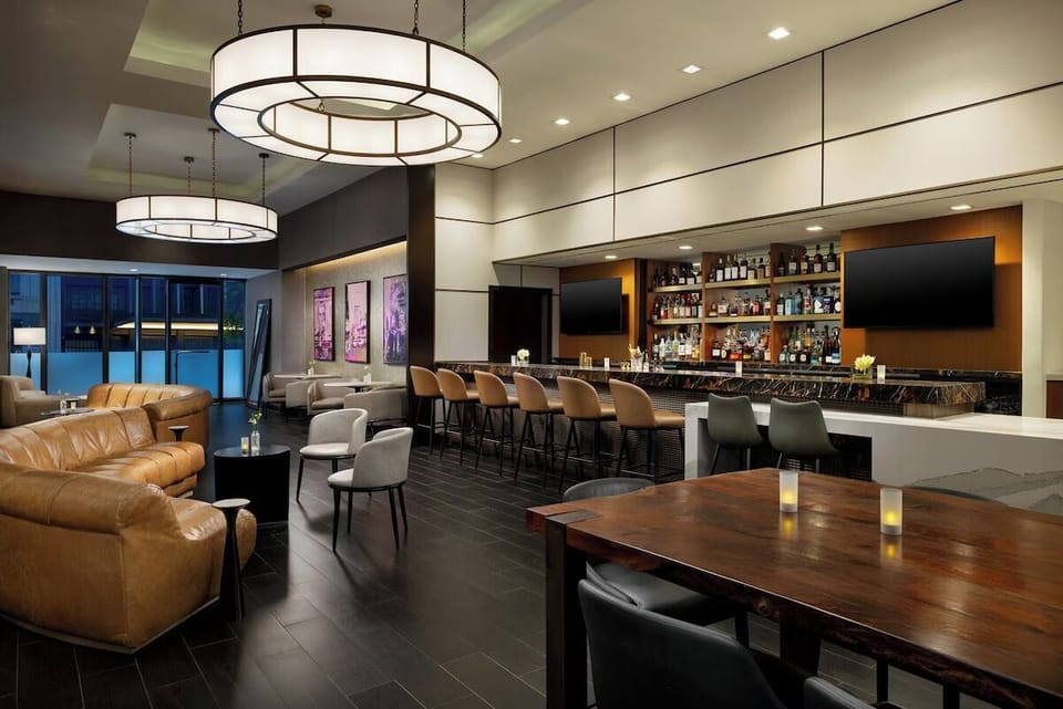 Sip crafted cocktails at the sleek bar with warm lighting.