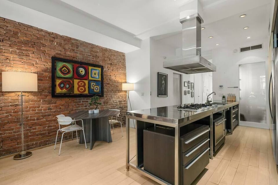 Giant kitchen with commercial-grade appliances and finishes. Cozy dining area.