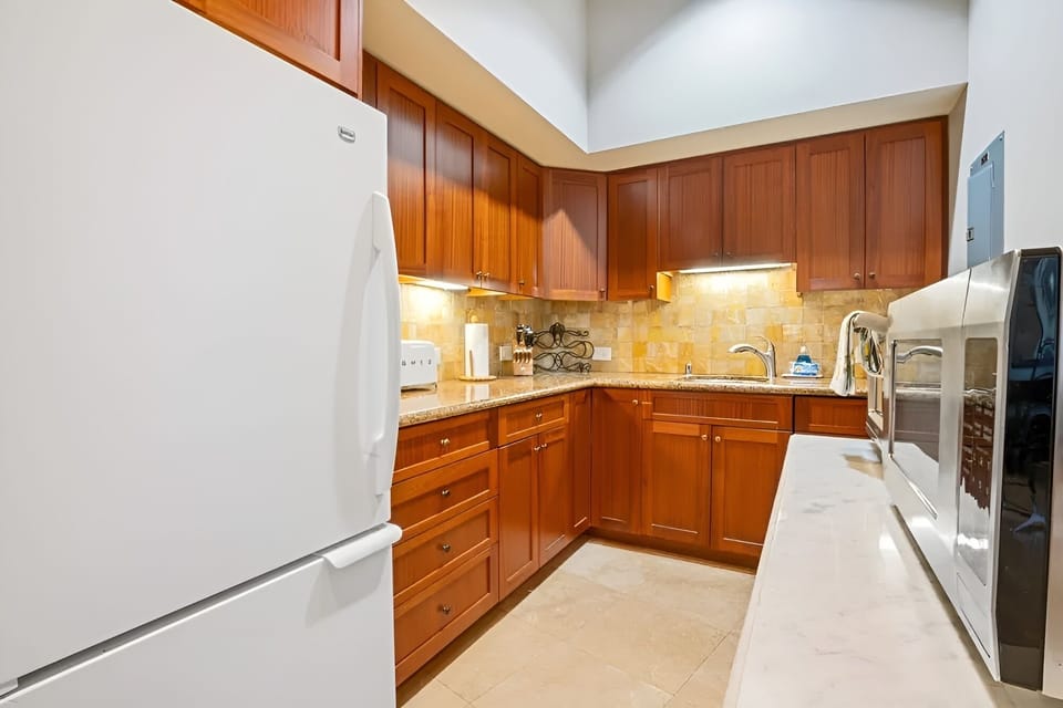 Prepare dinners smoothly in a well-lit kitchen with ample storage.