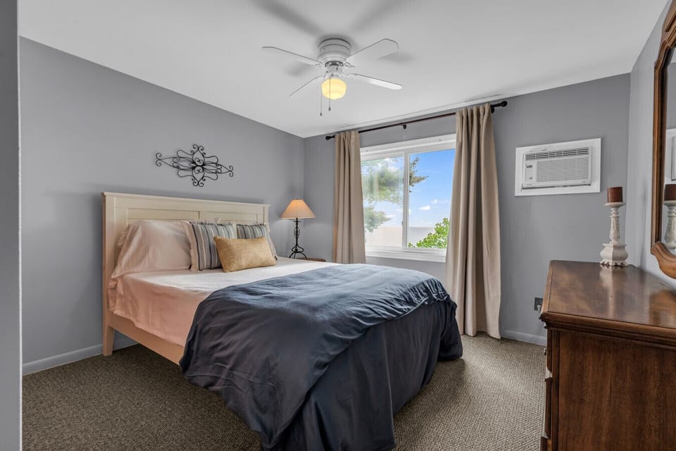 This is bedroom #2 with a queen bed. Clean lines, soft sheets, and a view that says nap time is sacred.