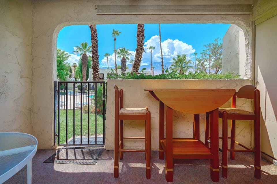 Enjoy serene outdoor living on this patio, featuring seating for four with stunning views of the pool and mountains. Perfect for relaxing and entertaining, this space offers a tranquil escape to unwind and take in the beautiful scenery. 
