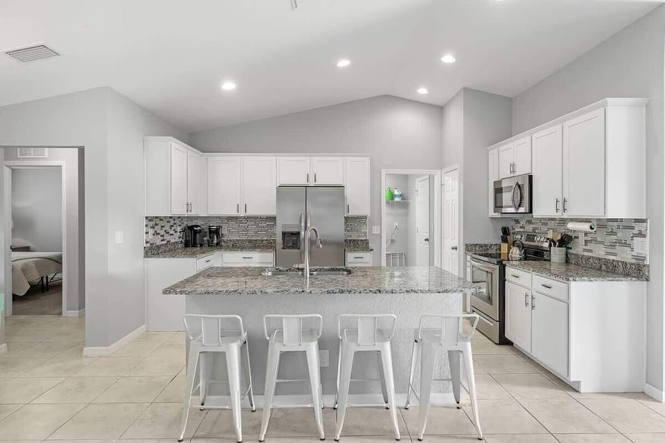 Fully equipped and stocked kitchen with all major appliances, kitchen table with 4 chairs and island with 4 stools.