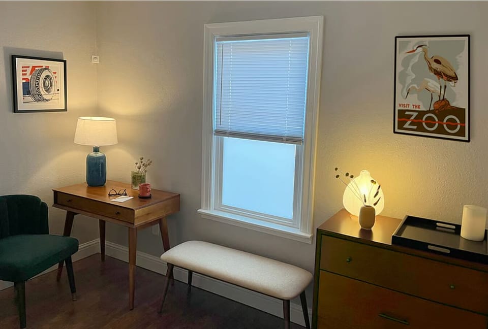 Front bedroom with bureau, bench, and desk