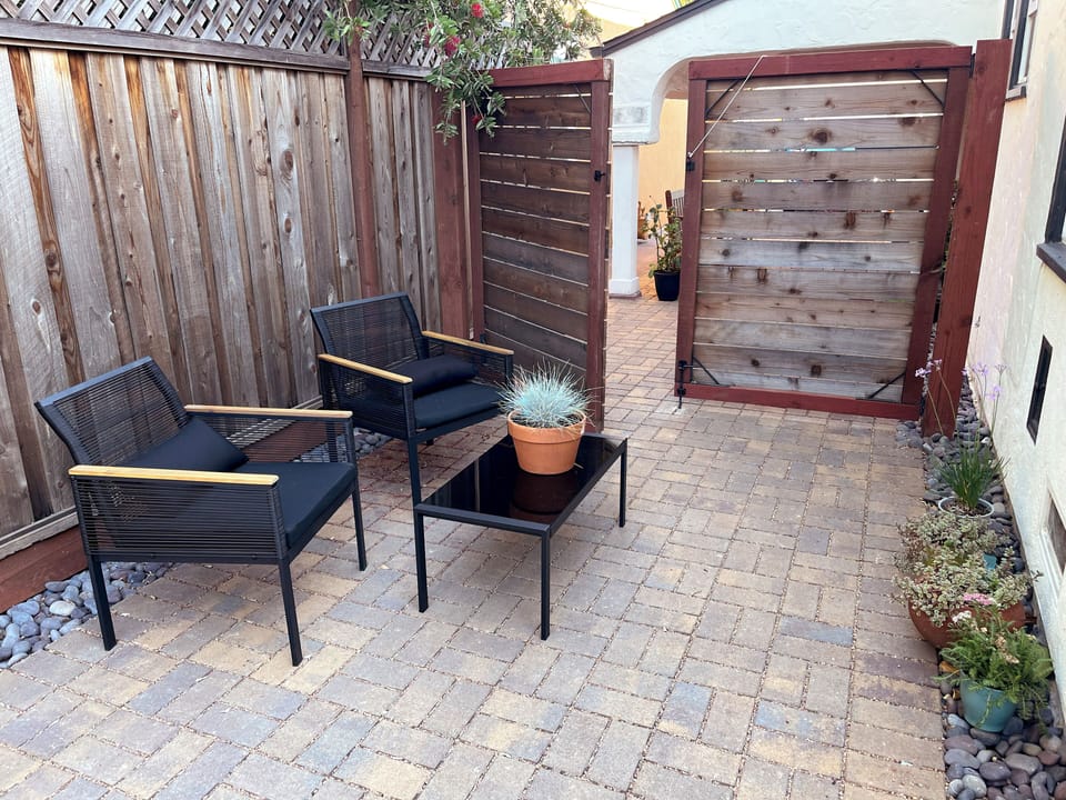 Cushioned chairs and coffee table on side patio.