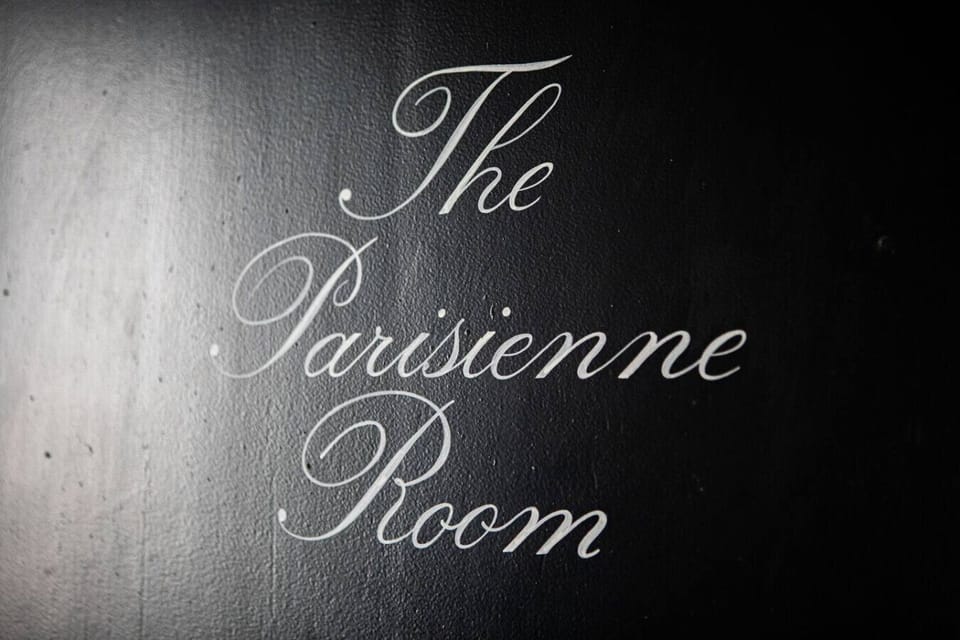 Signature `The Parisienne Room` nameplate.