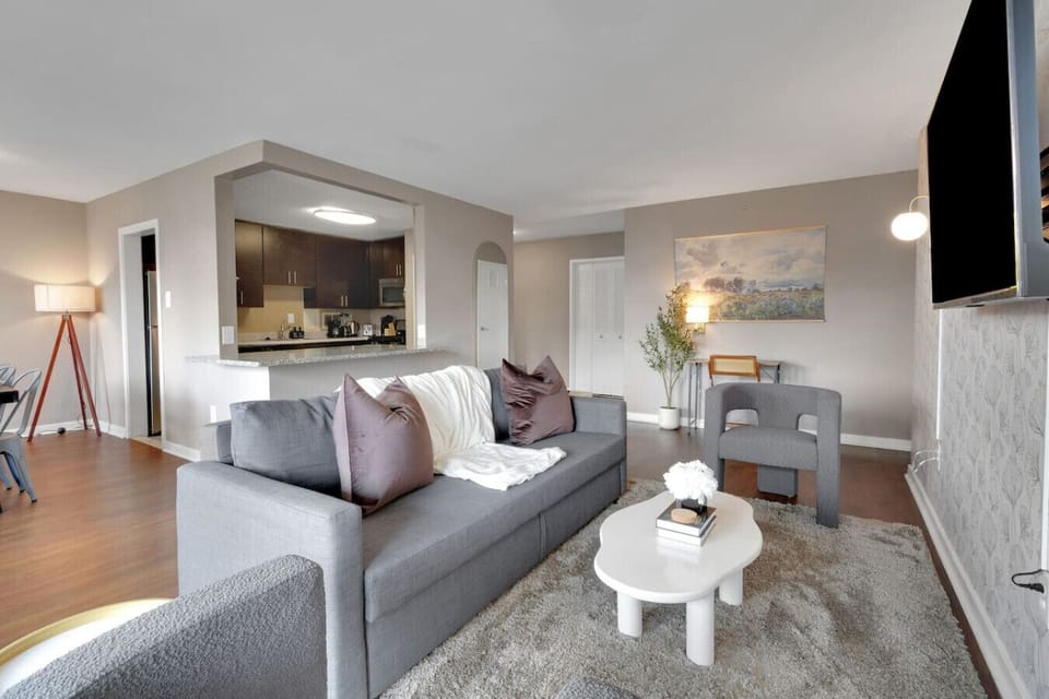 Designer ginkgo wallpaper, warm hardwood floors, and thoughtful lighting give this living space a layered, residential feel you won`t find in a standard hotel.