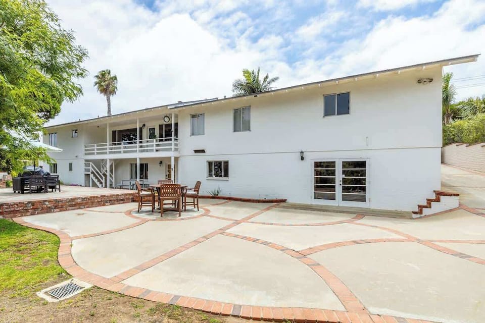 This spacious outdoor area features a charming patio with comfortable seating for al fresco dining and a sprawling lawn perfect for enjoying the California sunshine. 