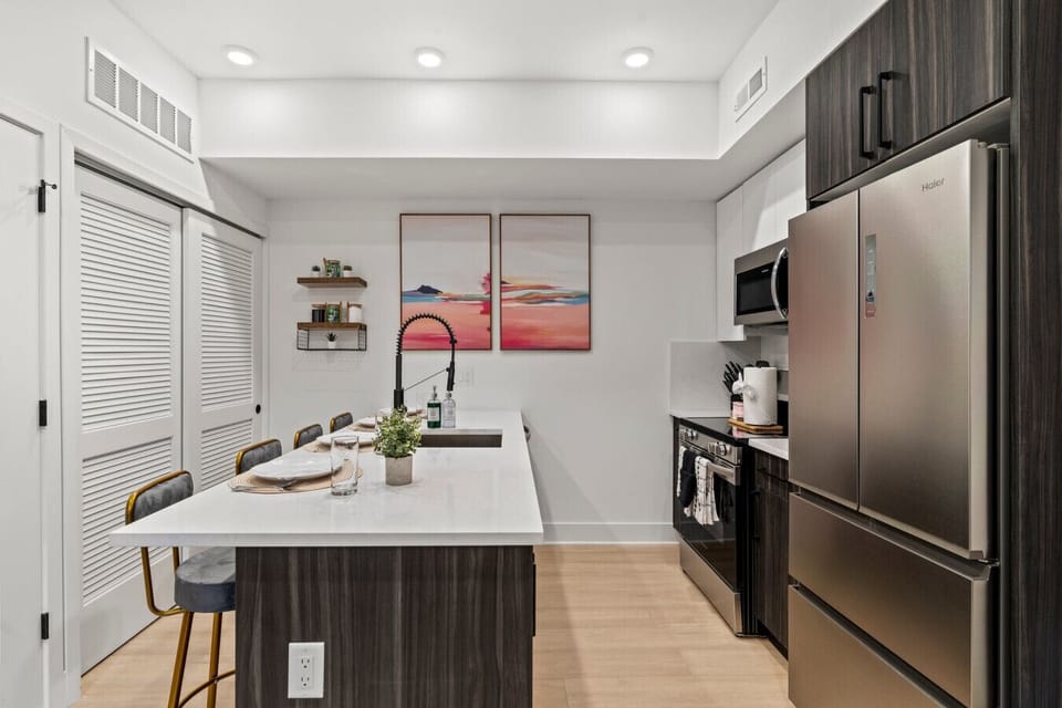 Chef’s Kitchen: Spacious gourmet kitchen featuring a large quartz island, bar seating for 3, and professional stainless steel appliances.