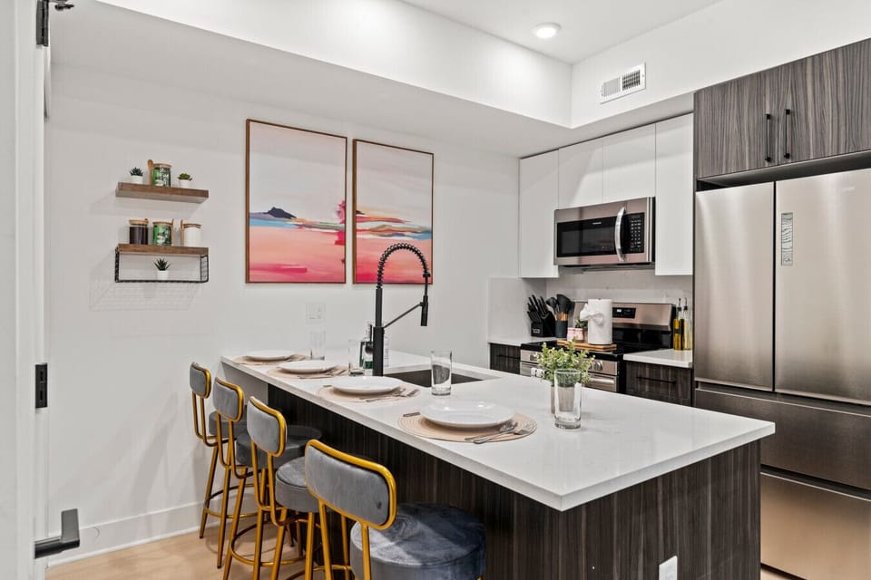 Chef’s Kitchen: Spacious gourmet kitchen featuring a large quartz island, bar seating for 3, and professional stainless steel appliances.