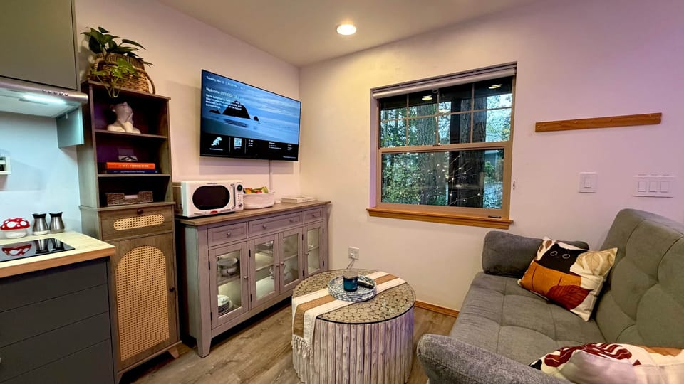 Relax in the living room with a sofa that easily converts into a bed, warm lighting, and a smart TV 