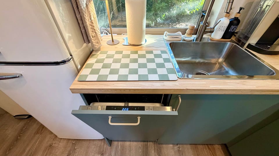 Integrated dishwasher seamlessly concealed behind a custom cabinet panel.