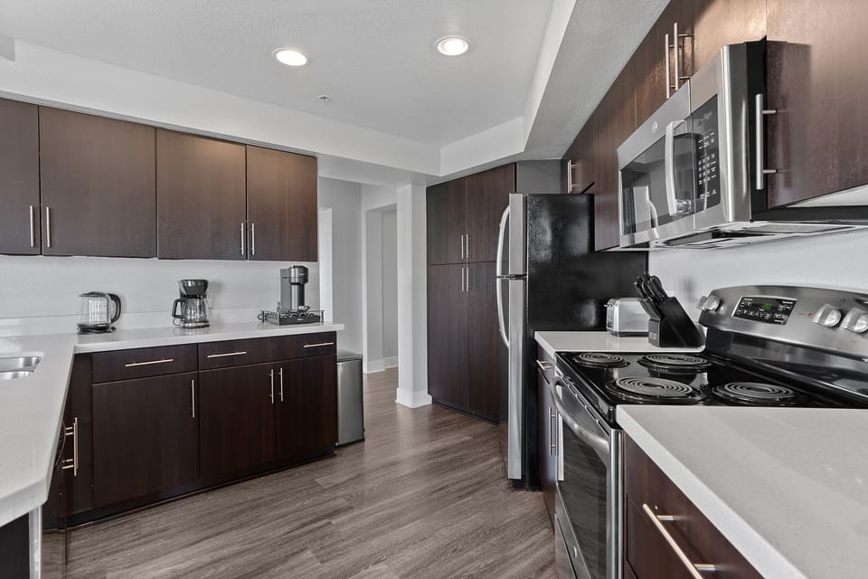 Kitchen is featuring stainless steel appliances and sleek quartz countertops
