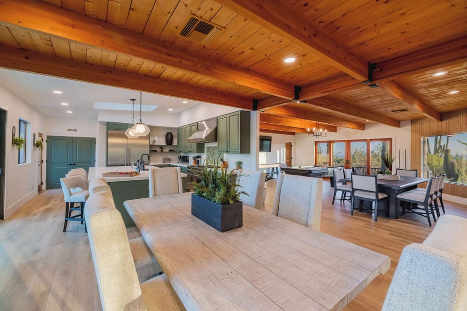 Bright, open kitchen with chef-grade appliances, massive island, and beautiful wood beam accents — ideal for group cooking.
