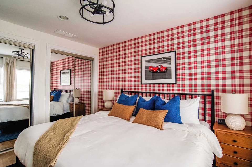 Kick back in this vibrant bedroom, where bold plaid walls, cozy bedding, and comfy touches set the perfect mood for a great night’s sleep.