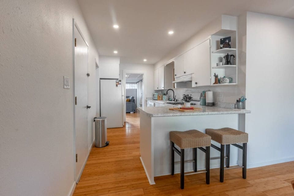 Enjoy a sunny, fully outfitted kitchen with plenty of counter space, sleek appliances, and a cozy breakfast bar—great for sipping coffee or making delicious meals anytime.