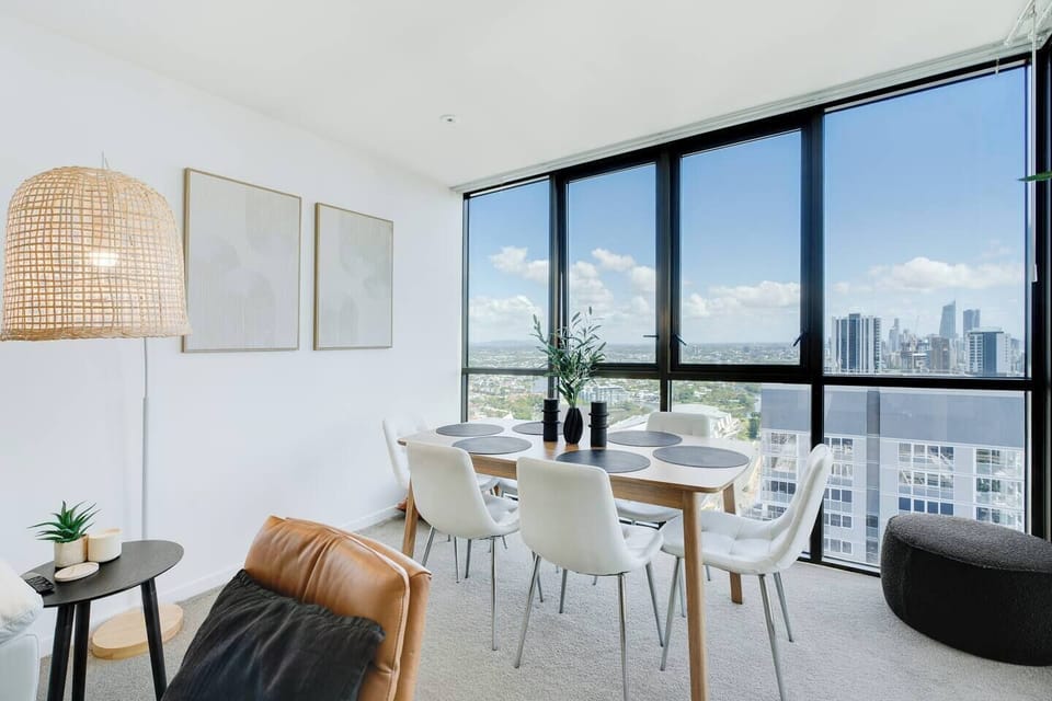 Share meals and moments at the six-seat dining table, set beside floor-to-ceiling glass framing breathtaking city and skyline views.