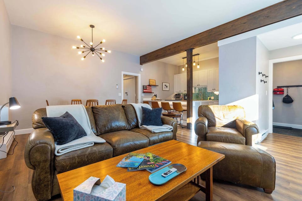 Living room with fireplace and large smart tv. Dining room and kitchen