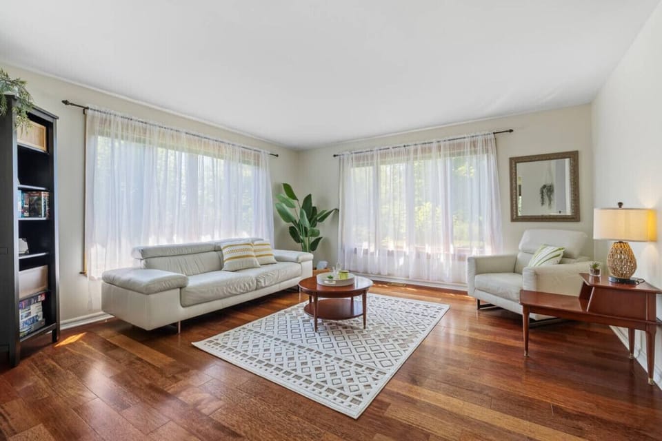 Bright and cozy living room with natural light, hardwood floors, and comfortable seating — perfect for relaxing after a day out.