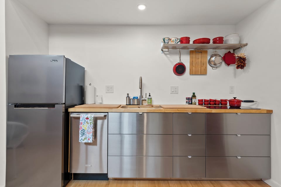 Kitchen with fridge, dishwasher, sink, stovetop, microwave and toaster oven.
