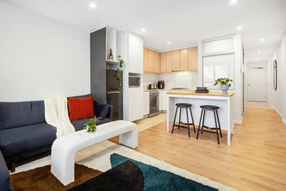 The open-plan layout brings together the living, kitchen, and balcony spaces, creating an easy flow for quiet mornings, casual meals, and evenings spent unwinding indoors.