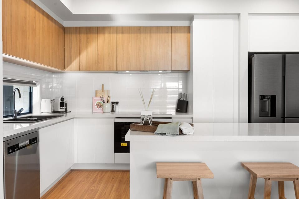 Modern appliances, generous bench space, and island seating make the kitchen ideal for everything from quick breakfasts to shared dinners.