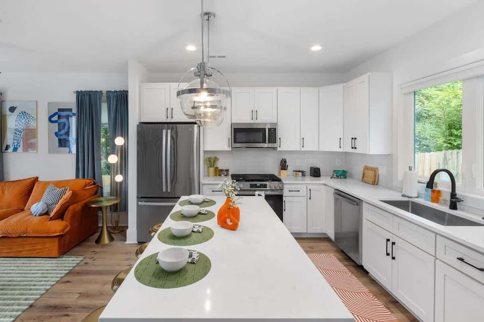Bright kitchen island with seating and modern lighting.