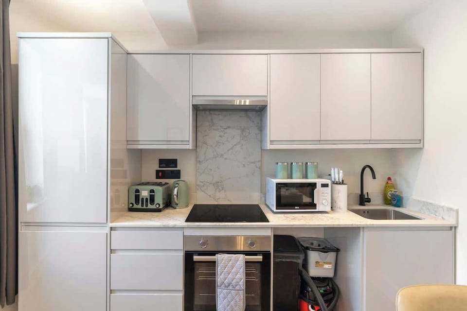 - Fully equipped kitchen with oven, microwave, and modern cabinets  
- Sleek design with marble backsplash creates a stylish cooking area  
- Airbnb kitchen perfect for preparing meals during your vacation  
