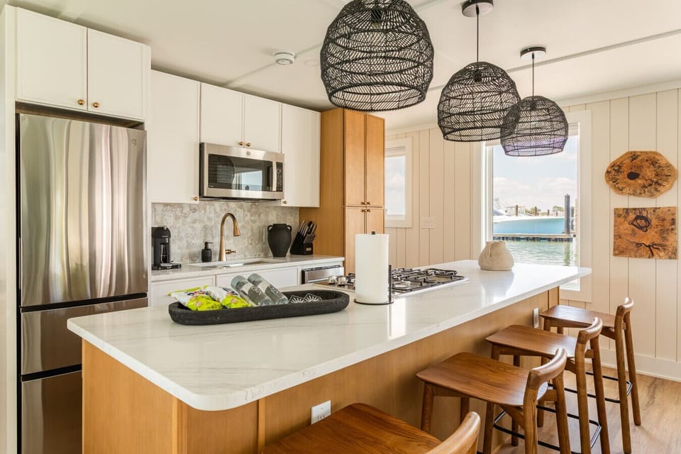 Fully stocked chef`s kitchen with quartz counters, stainless appliances, oak cabinetry, and a Nespresso coffee bar — designed for cooking with a view of the sportfishing fleet.
